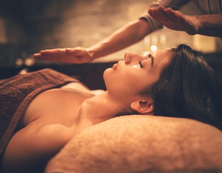 Woman lying down and relaxing with wellness massage from professional therapist at wellnes spa salon